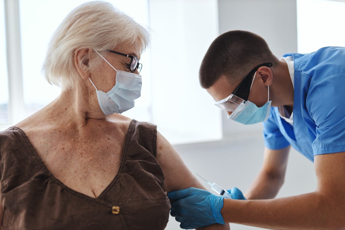 Pharmacist giving a flu vaccine to an older patient